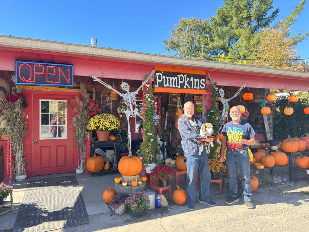 Owners Patrick and Jefferey stand in front of P&J's Nursery in Roger's Heights with their dog, Louie